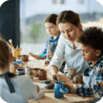 adult helping child paint pottery on purpose page