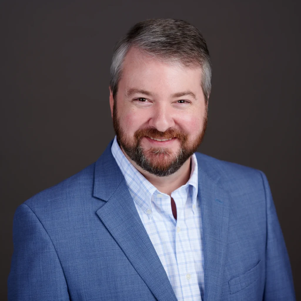 Mark Dixon in blue suit, smiling at camera